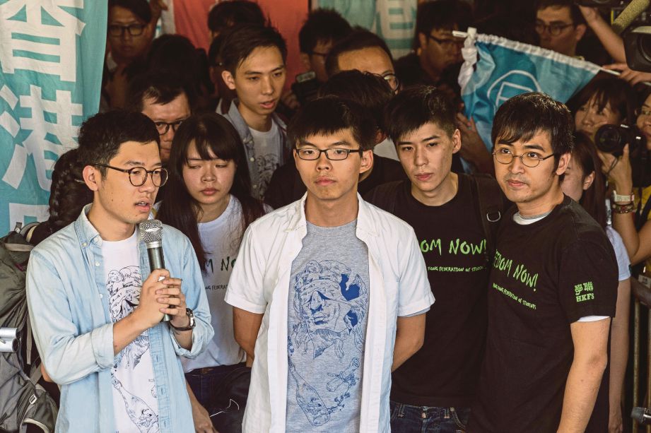 (DARI kiri) Law, Wong dan Chow berucap kepada penyokong mereka sebelum prosiding semalam. - EPA  