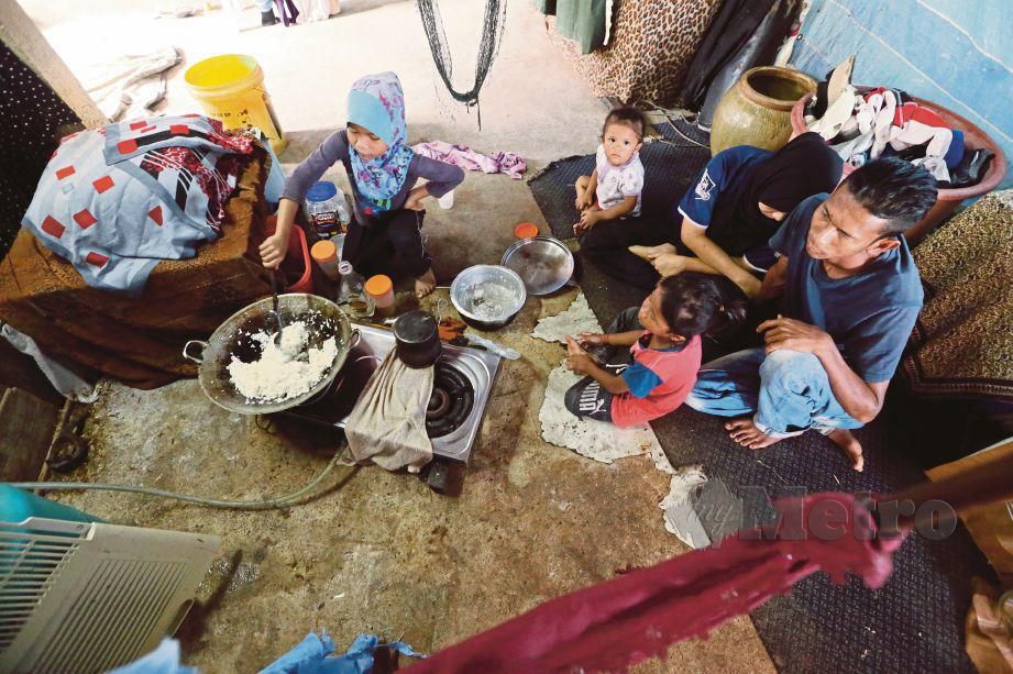 MOHD Ridzuan (kanan) bersama Siti Khodijah (dua dari kanan) menemani Nur Syasya Balqis memasak nasi goreng untuk juadah  berbuka puasa di rumah mereka. FOTO Amran Hamid 