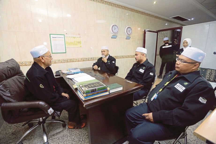 PETUGAS Unit Bimbingan Haji berbincang bersama  Hassan (kiri).   