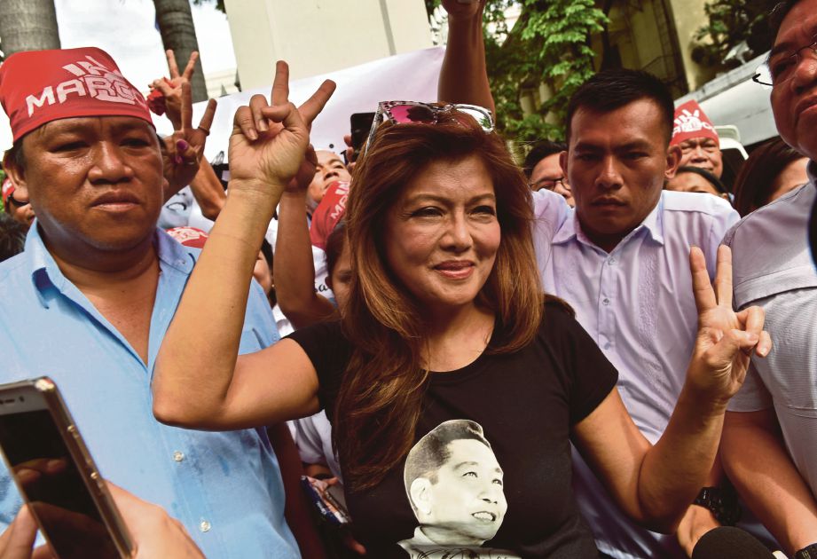 IMEE Marcos (tengah) menunjukkan isyarat tanda keamanan ketika menghadiri tunjuk perasaan di depan Mahkamah Agung Filipina di Manila,  semalam. - AFP