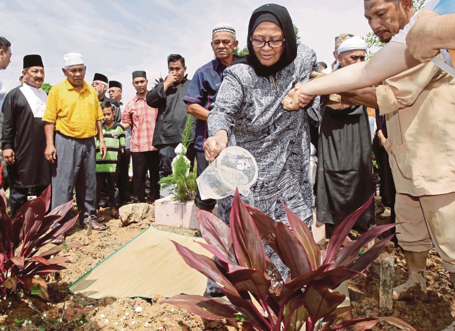  NABIHA menyiram air pada pusara  suaminya  di Tanah Perkuburan Islam Taman Kosas. 