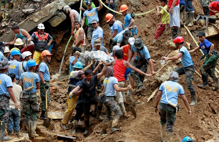 ANGGOTA penyelamat mengeluarkan mayat dari runtuhan tanah. - Reuters 