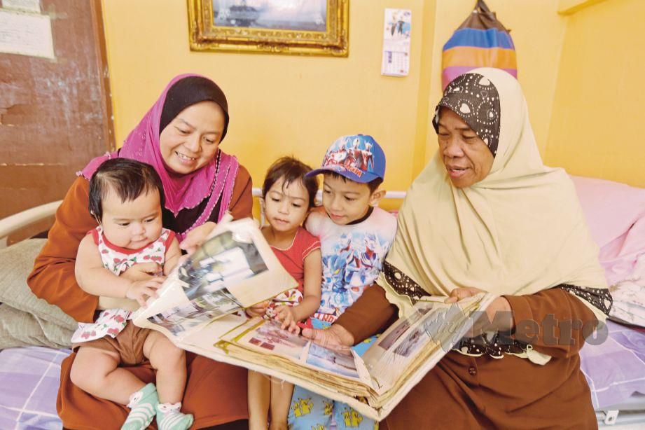  Halimah  (kanan) dan  Siti Aisyah melihat  gambar   arwah anaknya.