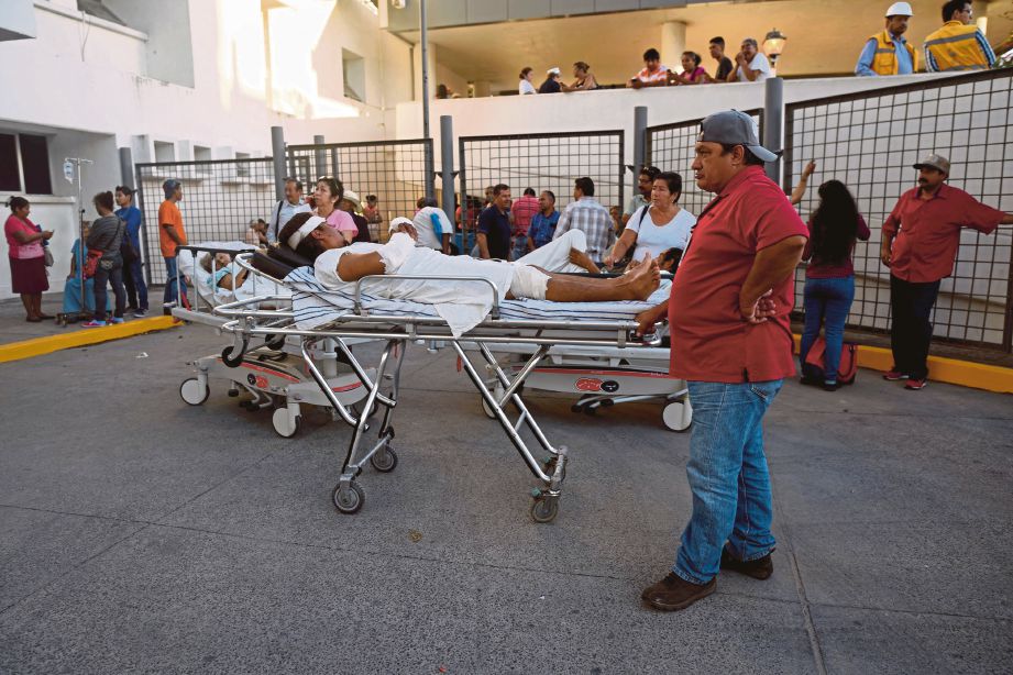 PESAKIT dan petugas berada di luar sebuah hospital sebagai langkah berjaga-jaga susulan gempa bumi kuat di wilayah Veracruz, Mexico kelmarin. - AFP