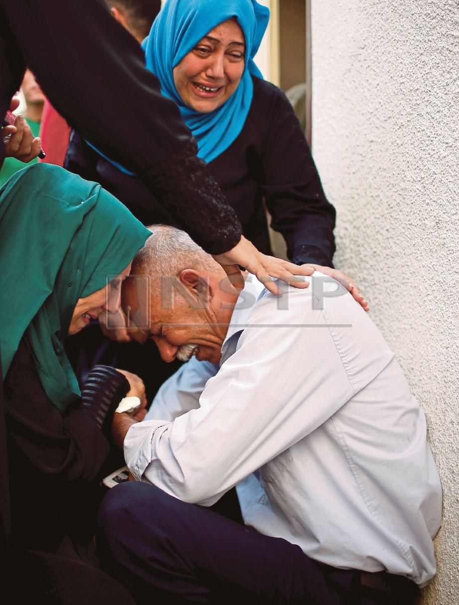  PENDUDUK dan sahabat  Naji Ahmed al-Za’anin sebak di pengebumiannya.