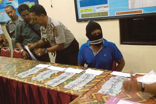 POLIS Indonesia menunjukkan sejumlah wang tunai dolar Amerika Syarikat dan seorang kru bot penyeludupan manusia yang didakwa menerima bayaran daripada pihak berkuasa Australia untuk berpatah balik.