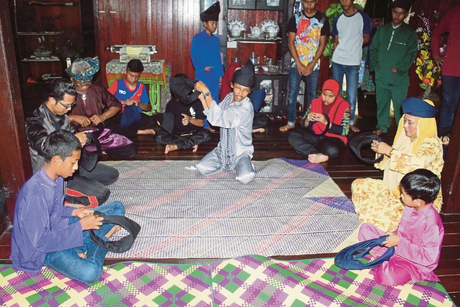 Anak Kampung Duyong berusia sekecil enam tahun serta golongan dewasa termasuk artis veteran, Wan Maimunah (dua dari kanan) diberi tunjuk ajar teknik melipat tengkolok adat anjuran JABAT.