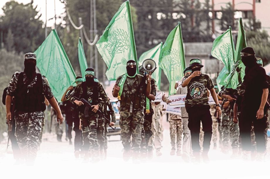 ANGGOTA Brigade Ezzedine al-Qassam, sayap bersenjata Hamas berarak di Khan Yunis di Semenanjung Gaza kelmarin. - AFP