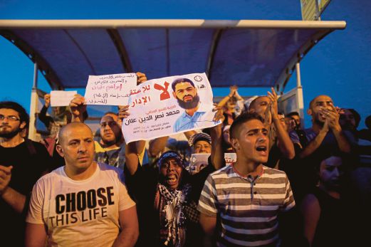 PENUNJUK perasaan Palestin menjulang gambar dan menggesa pembebasaan Mohammed Allaan ketika mengadakan demonstrasi di luar pusat perubatan Israeli Barzilai, Israel, tempat Mohammed dirawat. 