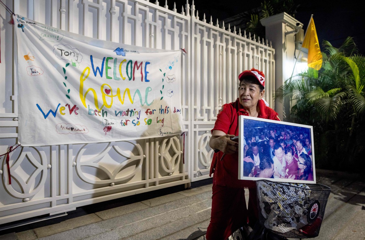 PENYOKONG Thaksin Shinawatra menunggu di luar rumah bekas perdana menteri itu susulan pembebasannya, hari ini. FOTO AFP.