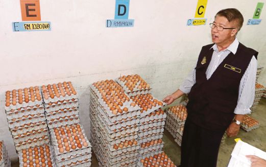  Chin    memeriksa harga dan kualiti telur   ketika  Ops Catut  di pasar awam Sama Gagah, Permatang Pauh, semalam.