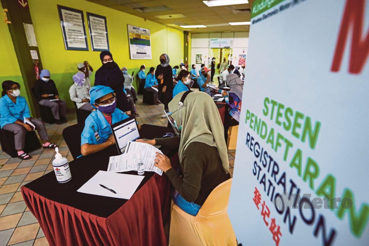 SEBAHAGIAN daripada pekerja kilang menunggu giliran pada Program Imunisasi Industri Covid-19 Kerjasama Awam-Swasta (Pikas) di kilang Minebea Electronics Motor (M) Sdn Bhd di Sungai Petani, Kedah.