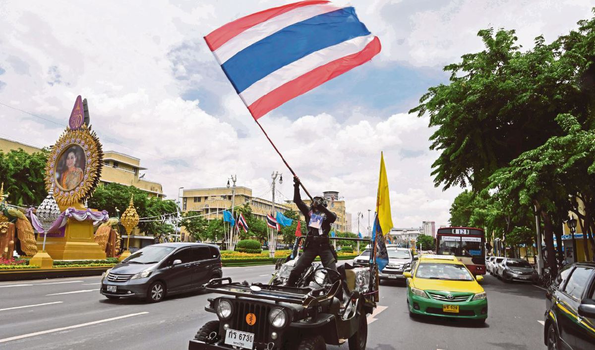 LELAKI memegang bendera Thailand. FOTO Fail AFP.