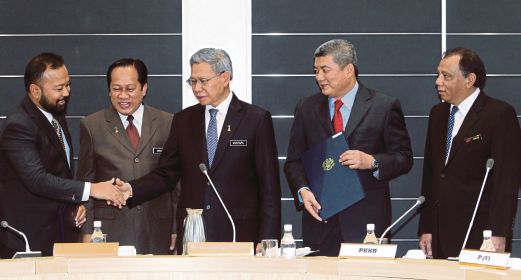 MUSTAPA (tengah) bersalaman dengan Pengarah Urusan Uzma Engineering Datuk Kamarul Redzuan Muhamed. 