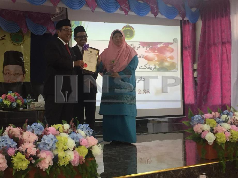 HARIS (kiri) menyampaikan sijil kepada waris pada Majlis Pengisytiharan Keputusan PSRA Selangor. FOTO ihsan JAIS