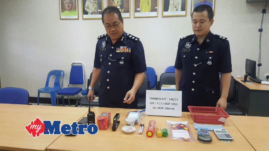 CHANG Keong (kiri) menunjukkan peralatan judi yang dirampas. FOTO Mohd Hafizee Mohd Arop