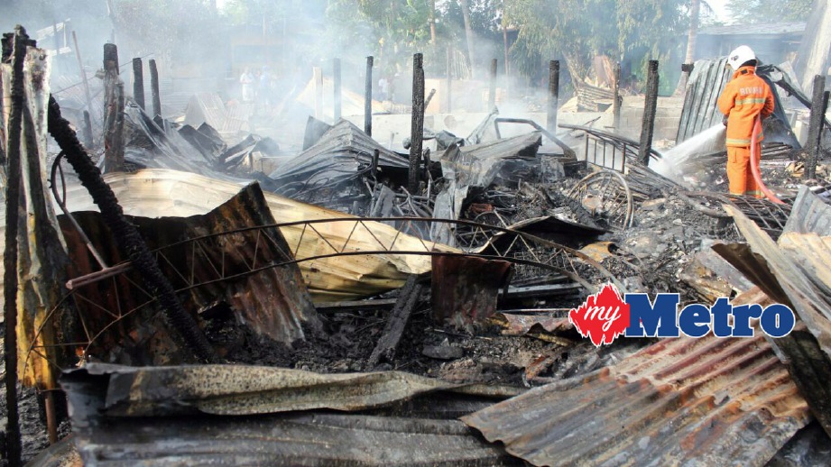 ANGGOTA bomba mengawal kebakaran di Kampung Pituru. FOTO  Erdiehazzuan Ab Wahid