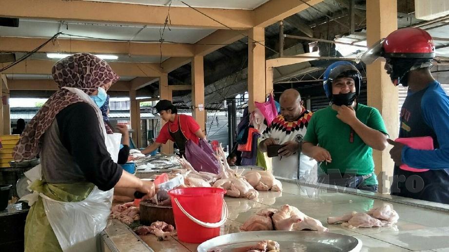 PENIAGA ayam segar di Pasar Besar Gua Musang tetap mendapat sambutan pembeli walaupun harga kekal RM9 sekilogram. FOTO Ramli Ibrahim