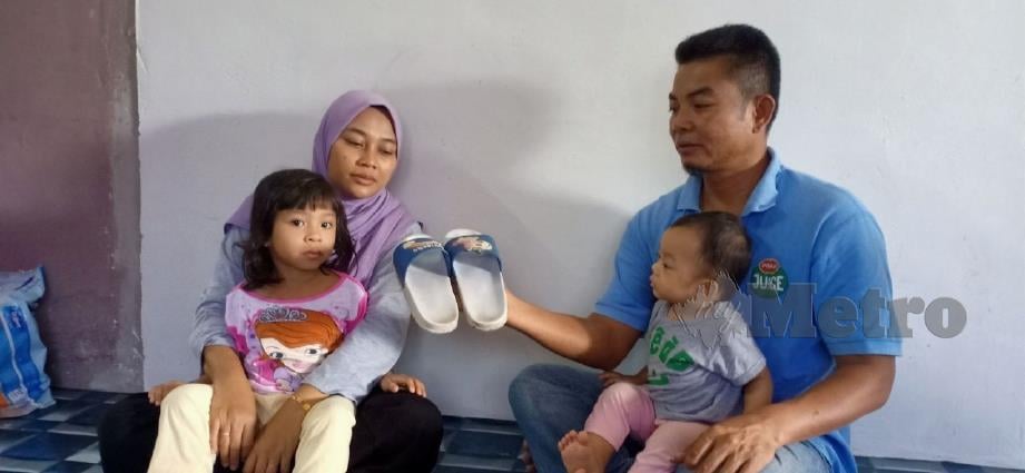 ZAIDI dan Suzana menunjukkan selipar diminta anak sulungnya,Nur Aida Rafhanah sebelum meninggal dunia akibat kemalangan langgar lari Januari lalu. FOTO Samadi Ahmad