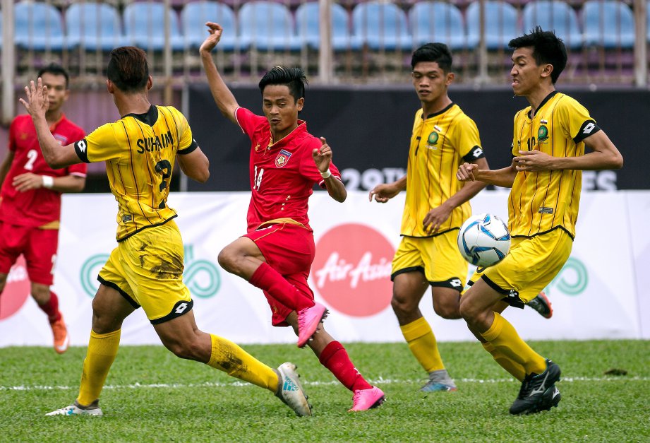  PEMAIN Myanmar Yan Naing Oo (tengah) melolosi tiga pemain Brunei  di Stadium Universiti Malaya (UM) Arena hari ini.