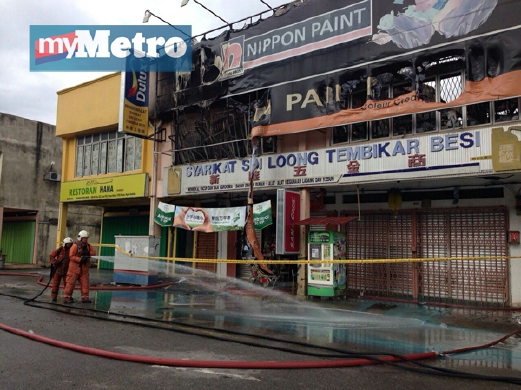 ANGGOTA Bomba memadam kebakaran di Pekan Rantau. FOTO Khairul Najib