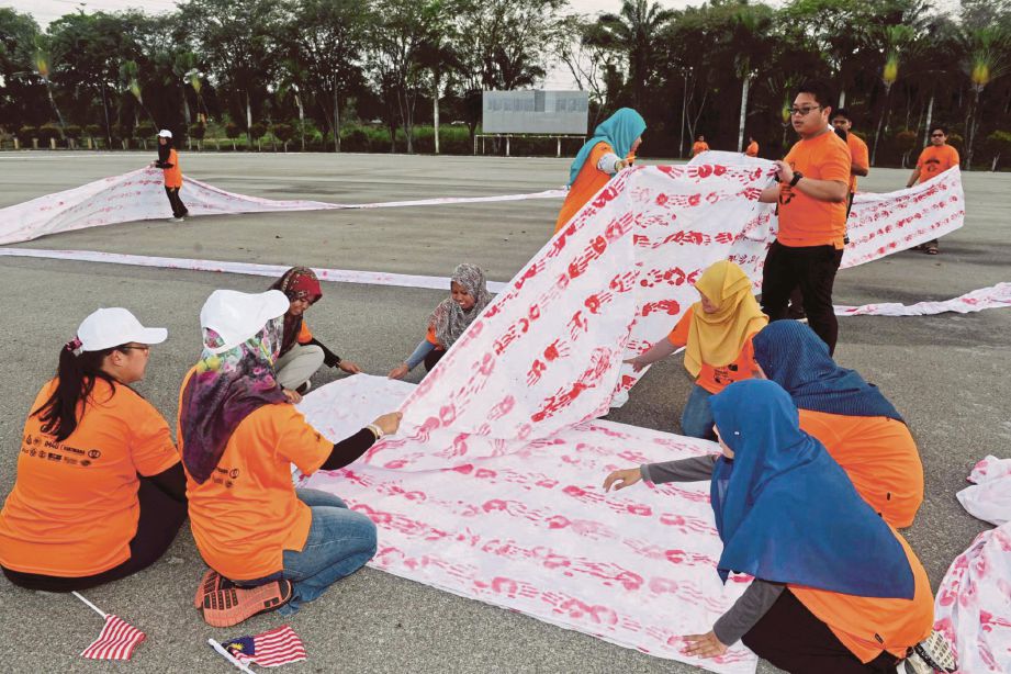 Peserta melipat bendera terpanjang sempena Program Kembara Amal Anak Merdeka Patriot 16 UTM, 2016 di Padang kawad UTM Skudai.