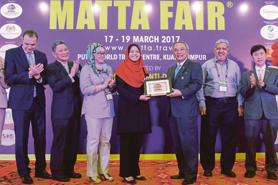  HAMZAH  (tiga dari kanan) menyerahkan cenderahati kepada Exco Perlancongan Negeri Perak Datuk Nolee Ashhilin Mohd Radzi di MATTA Fair 2017 di PWTC, semalam. 