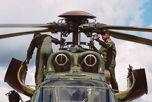  ANGGOTA pasukan mencari dan menyelamat membersihkan helikopter Super Puma di Pangkalan Bun selepas menyertai operasi, semalam.