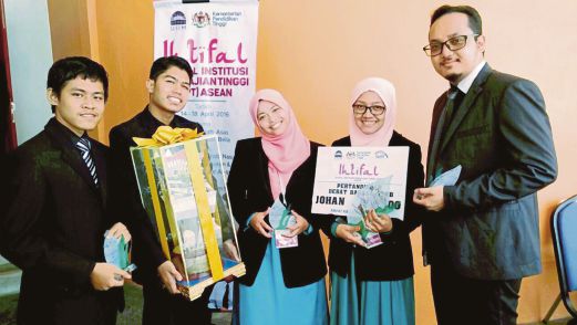 PENDEBAT USIM menunjukkan trofi kejuaraan Debat Bahasa Arab Ihtifal Institusi Pengajian Tinggi (IPT) ASEAN 2016.