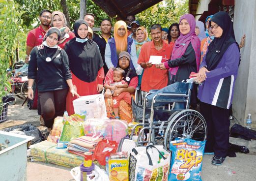  Zaitol menyampaikan sumbangan segera kepada Mohamad Sofi, disaksikan  Siti Aminah dan sukarelawan.