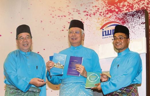 NAJIB melancarkan buku terbitan IWM ditemani Dr Abdullah (kiri) dan Mohd Yusof.