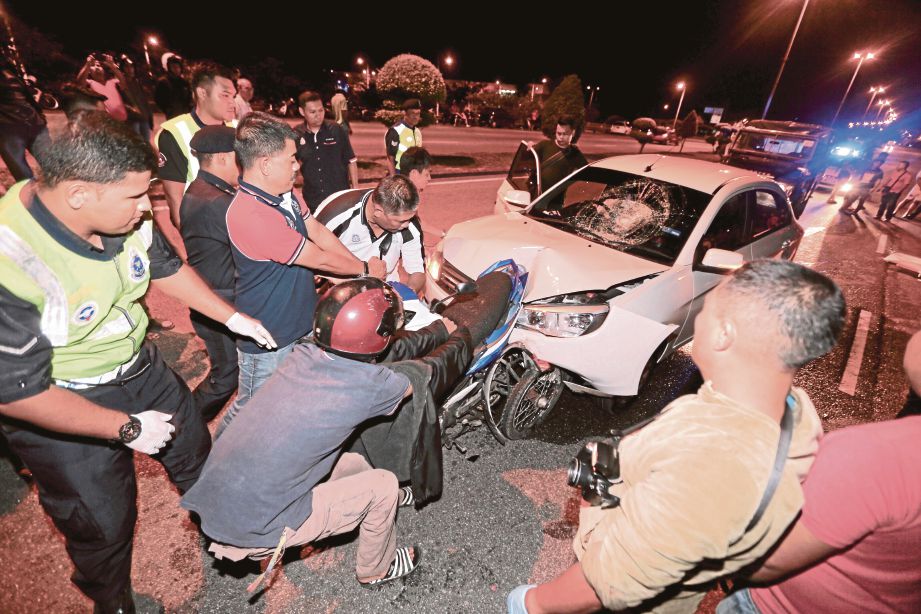 ANGGOTA polis dan orang awam cuba menarik motosikal Jamaludin yang maut dalam kemalangan di Lebuh AMJ dekat Bukit Baru.