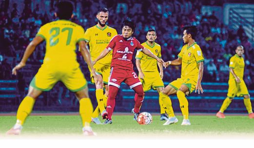 PEMAIN Sabah, Radzi Hussin (tengah) cuba melepasi pemain Kedah.