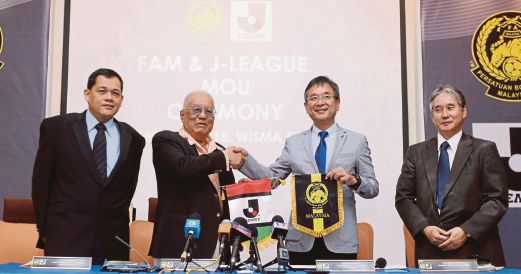 Pengerusi J-League Mr Mitsuru Murai bersalaman dengan Mokhtar (dua dari kiri) pada majlis pengumuman perjanjian perkongsian antara FAM dan J-League di Wisma FAM.