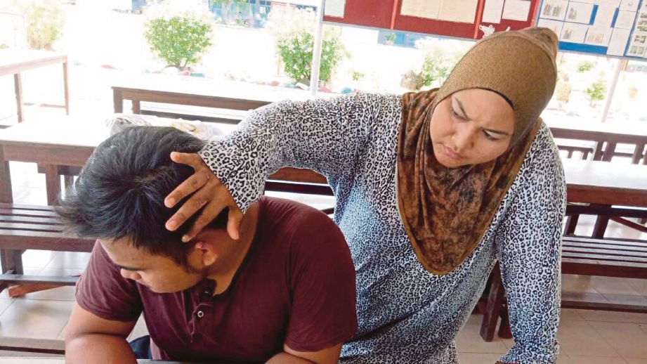 Rosnaliza  menunjukkan telinga Habib yang cedera dalam kejadian samun di Pantai Cahaya Negeri, Port Dickson. 