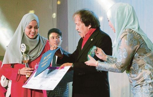 Makhtar menyampaikan anugerah kepada  Siti Zubaidah.