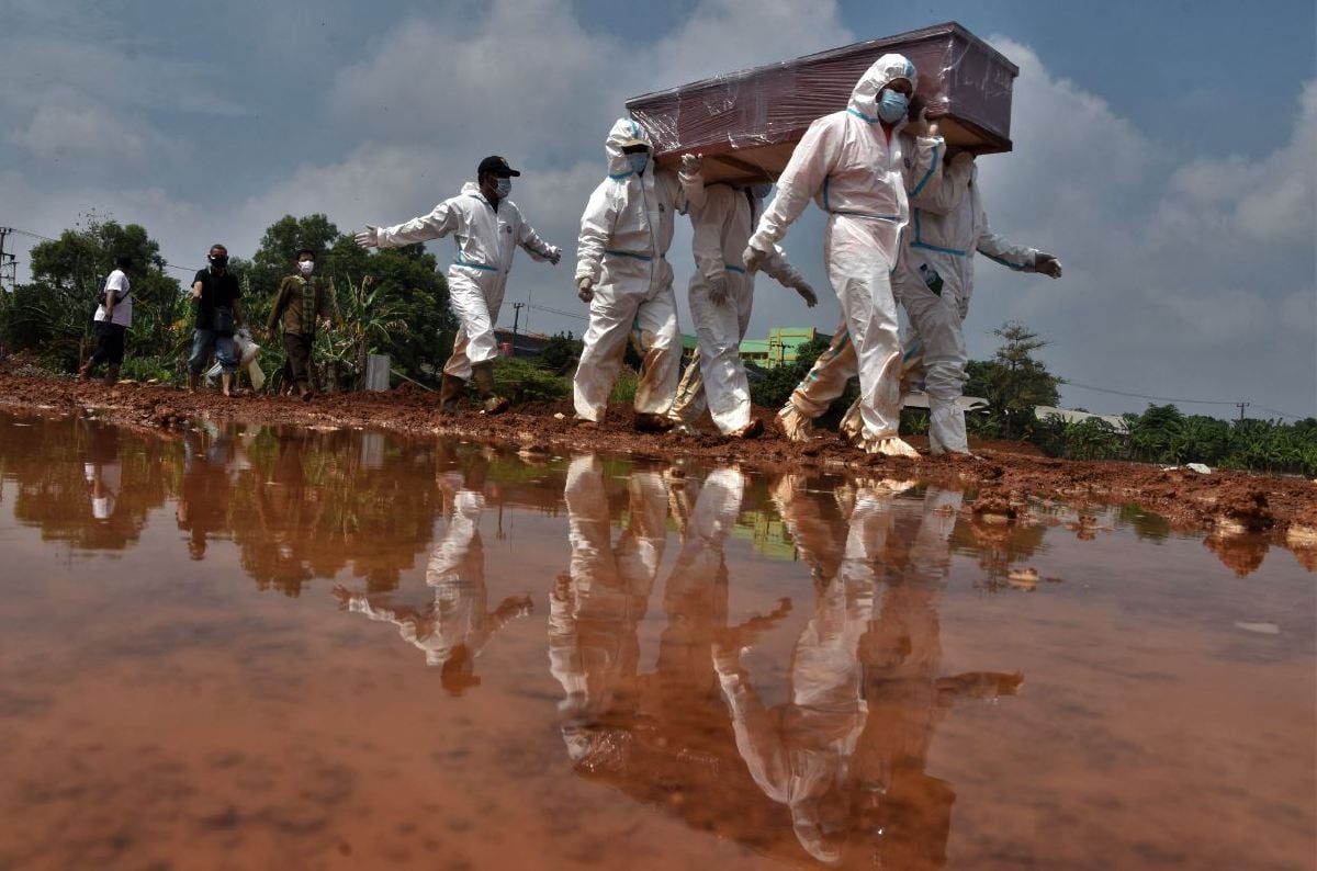 PETUGAS mengurus jenazah pesakit Covid-19  di tanah perkuburan di Bekasi, Indonesia ketika pandemik memuncak pada Ogos 2021. FOTO AFP.