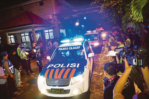 KERETA polis mendahului ambulans membawa lima mayat banduan yang ditembak mati di Penjara Nusakambangan di Cilacap, Jawa Tengah awal pagi semalam. 