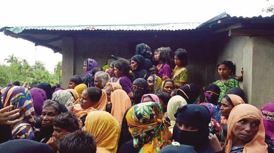 PELARIAN Rohingya menerima bantuan makanan di Kem Balukhali, dekat Cox’s Bazar, Bangladesh.