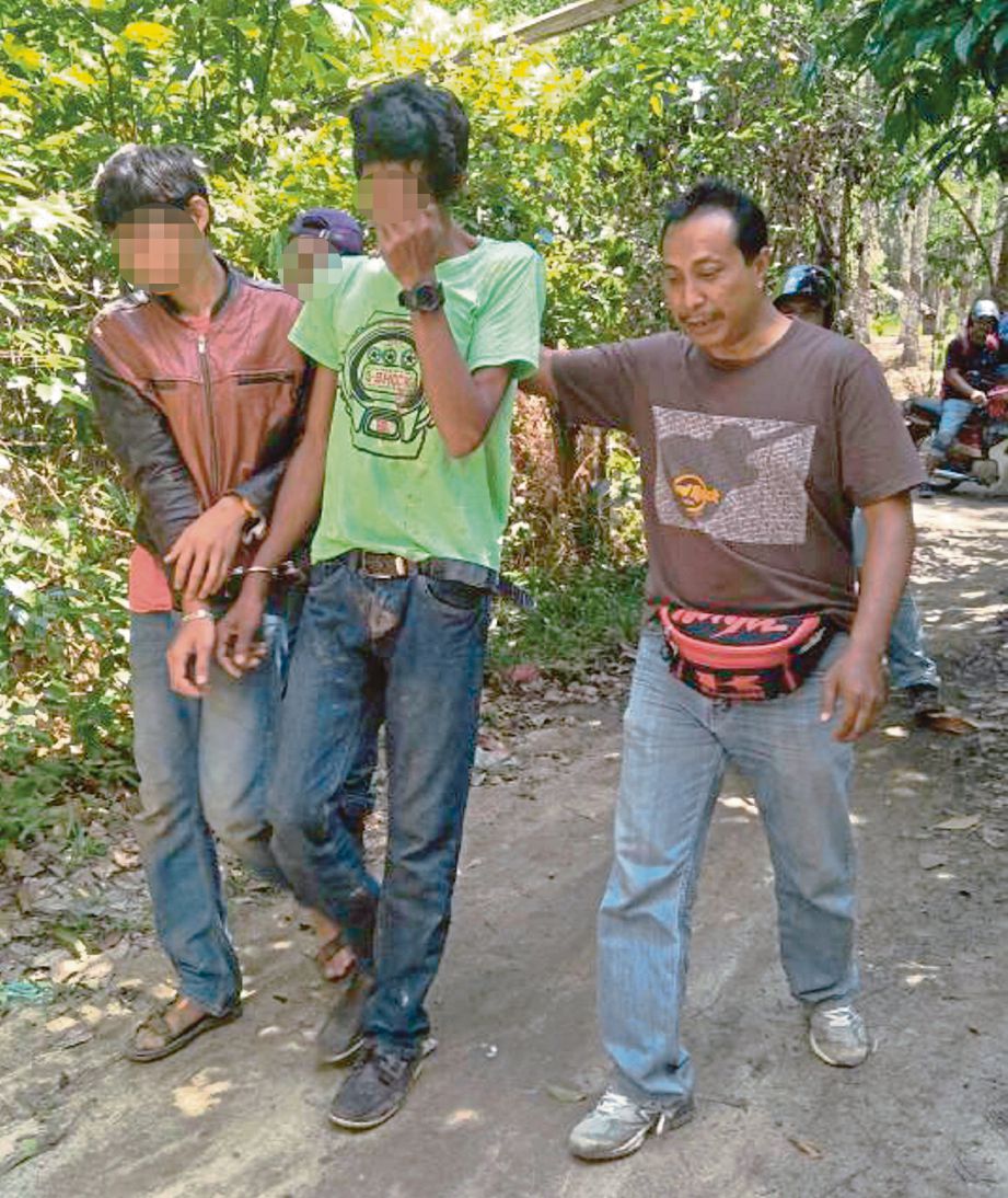 TOKAN (tengah) ditahan dalam serbuan di kebun getah yang dijadikan port dadah di Kampung Baru, Sungai Tiang.