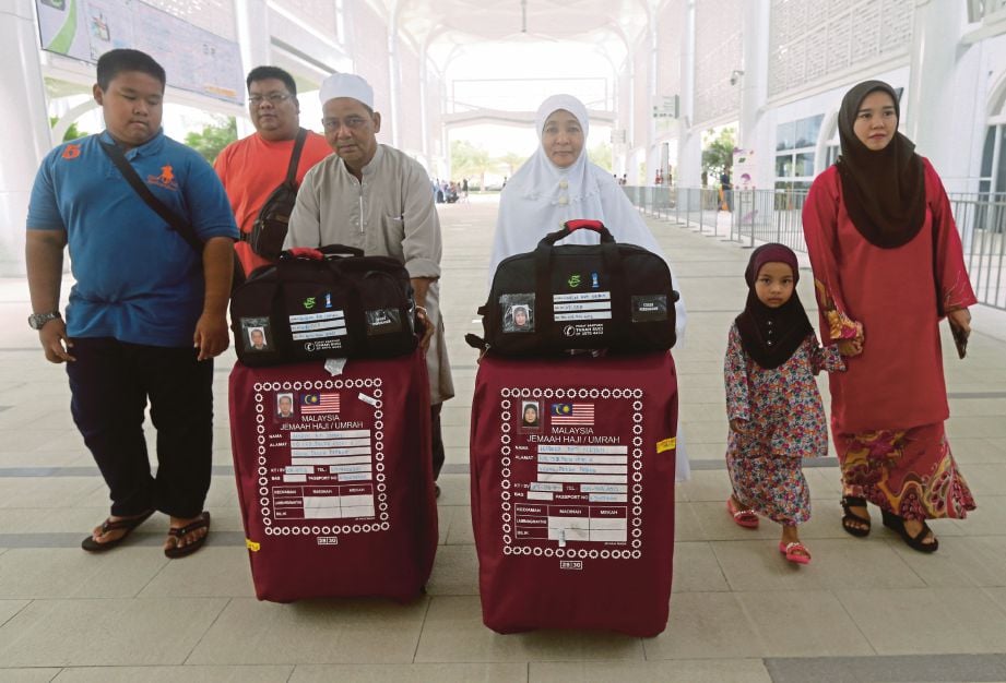 HASHIM bersama Habsah menolak bagasi ketika tiba di Kompleks Tabung Haji, Sepang, semalam.