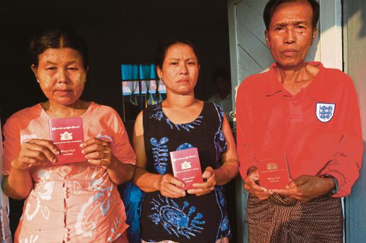 IBU bapa suspek warga Myanmar menunjukkan pasport mereka untuk ke Thailand selepas mendakwa anak mereka diseksa dalam tahanan.