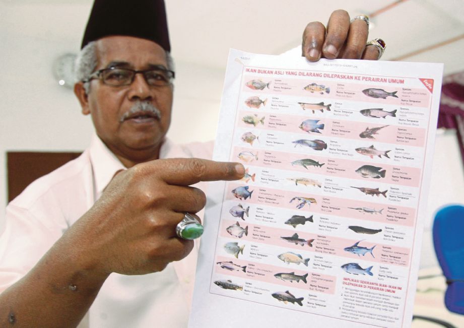 MUHAMAD Yusoff menunjukkan senarai 34 ikan yang dilarang untuk dilepaskan di perairan negara.