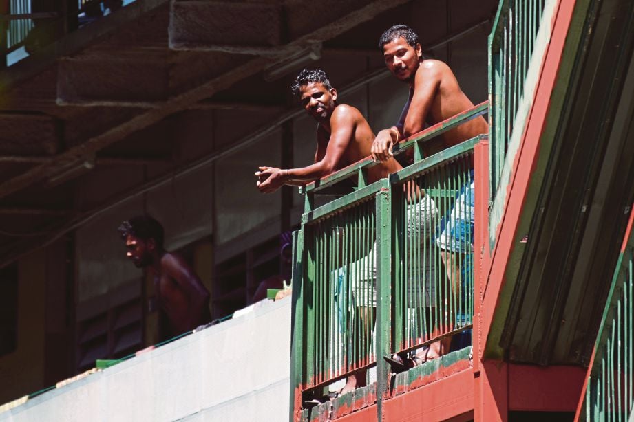 PEKERJA asing yang dikuarantin meninjau dari  balkoni asrama  di Cochrane Lodge 2, Singapura. 