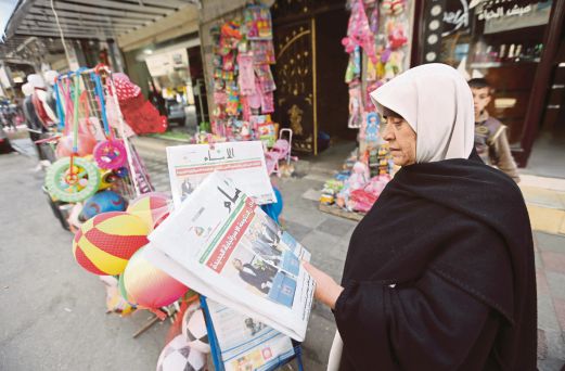 SEORANG wanita Palestin membaca muka depan sebuah akhbar Palestin mengenai pilihan raya Israel, di Khan Younis, selatan Semenanjung Gaza, semalam.