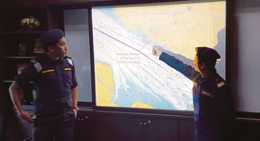  MUHAMMAD Zulkarnain (kiri) dan Pengarah Operasi Pangkalan, Lt Maritim Mohd Khairul Anwar menunjukkan peta lokasi di mana mangsa dikhuatiri lemas.