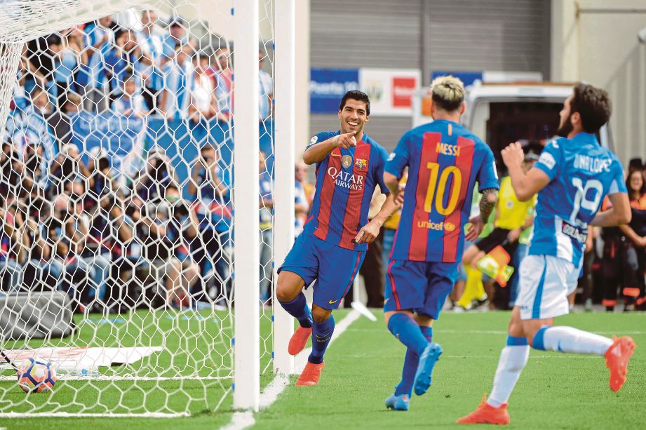 SUAREZ (kiri) meraikan jaringannya bersama Messi (tengah).