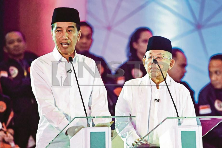 JOKOWI (kiri) dan pasangannya Ma’ruf Amin bercakap ketika debat televisyen di seluruh negara di Jakarta pada 17 Januari lalu. - AFP