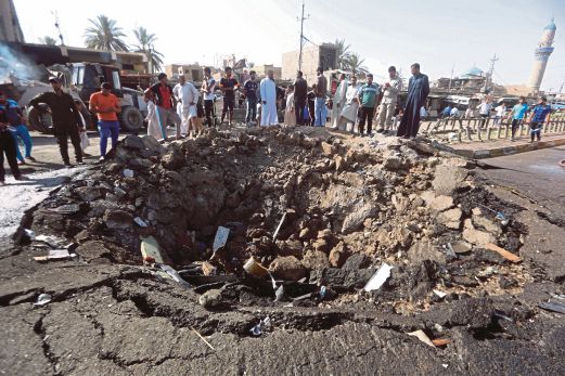 ORANG ramai melihat lokasi serangan bom kenderaan di bandar Khan Bani Saad.