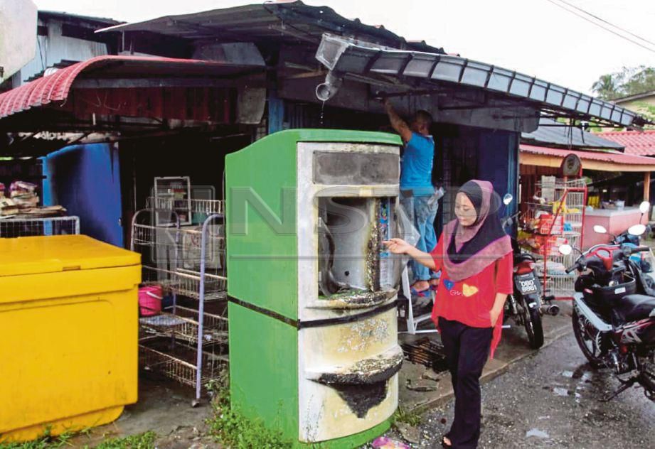 NOR Farahim  menunjukkan mesin air yang hangus dijilat api akibat  mengisi petrol berhampiran  lilin   di Kampung Telaga Bata. 